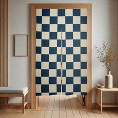 a room with a checkerboard pattern on the wall and wooden flooring in front of it