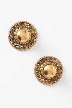 two pairs of gold toned earrings on a white background, one with an intricate design