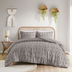 a bed in a bedroom with two plants hanging on the wall