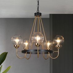 a chandelier with five clear globes hanging from it's metal frame