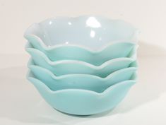 four blue bowls are stacked on top of each other in the shape of wavy waves