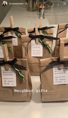 small brown bags with black ribbons tied around them and tags attached to the handles are sitting on a counter top