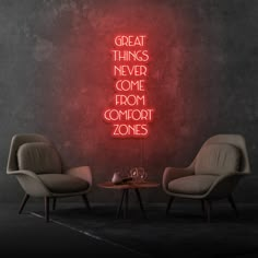 two chairs sitting next to each other in front of a neon sign that says great things never come from comfort zones