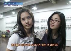 two young women are standing together in an office