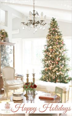 a living room with a christmas tree and chandelier in the corner next to a couch