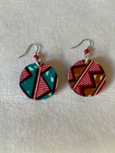 Wax-print based, double-sided earrings in a multitude of shapes, sizes, colors, and patterns; affordable hand made and one of a kind using genuine Ghanaian fabric and beads. Rustic edges. Circle measures 1.5in in diameter. Multicolor Geometric Earrings For Gift, Geometric Multicolor Earrings For Gift, Geometric Multicolor Earrings As Gift, Handmade Brown Geometric Earrings, Handmade Multicolor Geometric Jewelry, Unique Handmade Geometric Earrings, Handmade Geometric Multicolor Jewelry, Ghanaian Fabric, Double Sided Earrings