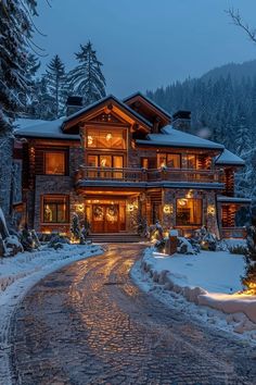 a large house is lit up at night in the snow