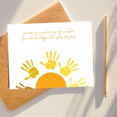 a card with handprints on it next to a pencil