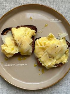 two pieces of toast topped with eggs on top of a white and brown plate sitting on a table