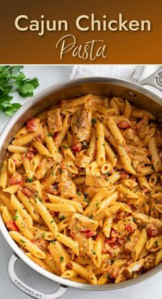 a large pot filled with pasta and meat on top of a table next to parsley