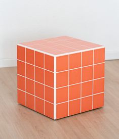 an orange cube sitting on top of a hard wood floor