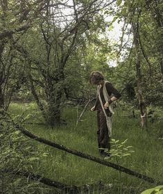 a woman standing in the middle of a forest