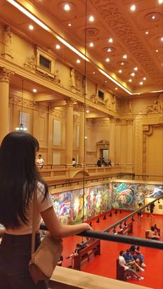 a woman standing in front of a glass window looking at the inside of a building