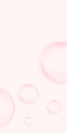 three bubbles are floating in the air on a pink and white background that appears to be liquid