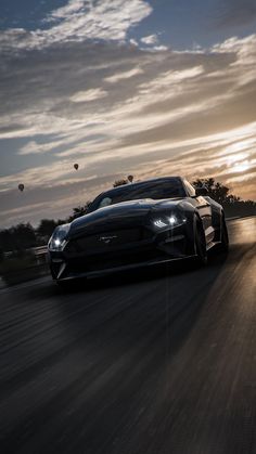 a car driving down the road at sunset