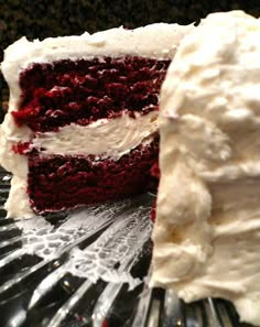 a piece of red velvet cake with white frosting