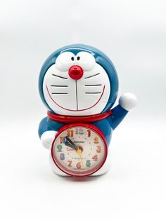 a blue and white cat clock with red hands