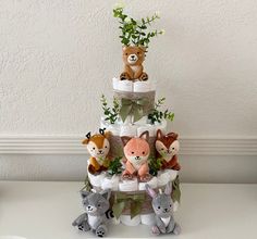 a stack of diapers with stuffed animals on top and flowers in the bottom tier