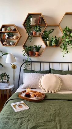 a bed with green bedspread and wooden hexagonal shelves above it