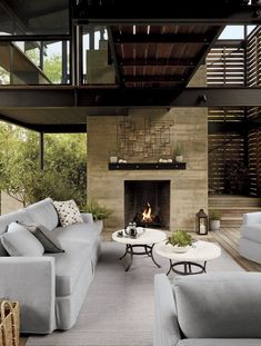 a living room with two couches and a fire place in the middle of it