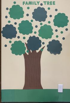 a family tree made out of paper and cutouts on the side of a wall