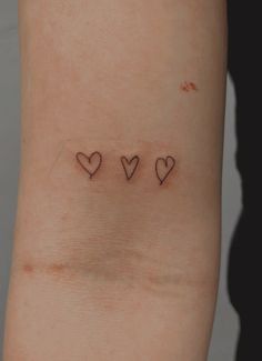 three hearts tattoo on the left side of the right arm, with one heart in the middle