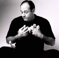 a man sitting on the floor with his hands together