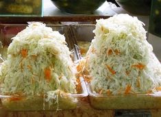 two trays filled with food sitting on top of a counter next to each other