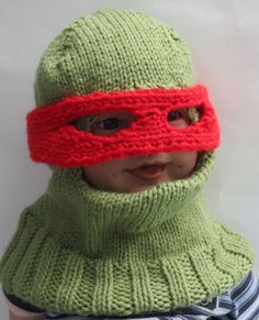 a child wearing a green knitted hat and red mask