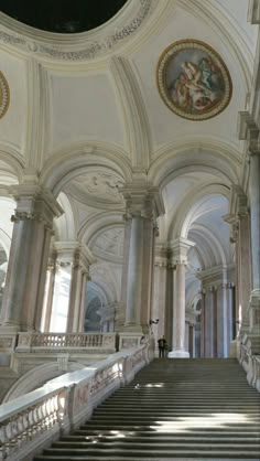 an ornate building with stairs and paintings on the walls