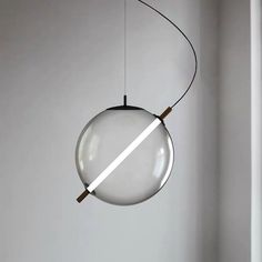 a round light hanging from a ceiling in a room with white walls and flooring