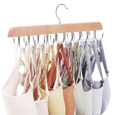 an assortment of bras hanging from a wooden hanger on a white background,