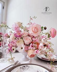 the table is set with pink and white flowers