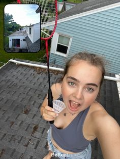 a woman holding a tennis racquet in front of her face with a house in the background