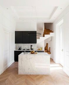 a kitchen with marble counter tops and an island in the middle, along with wooden flooring