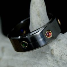 a close up of a metal ring with two colored stones on the inside of it