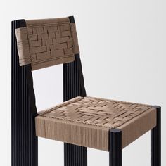 a chair made out of woven material with black legs and an upholstered seat