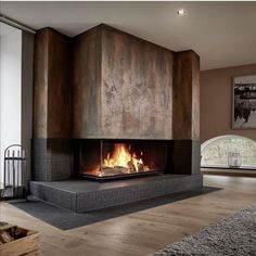 a modern fireplace in the middle of a living room with wood flooring and walls