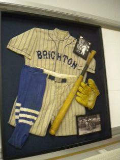 a baseball uniform and glove on display in a case