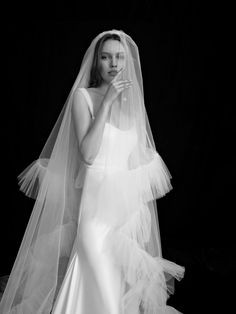 a woman in a wedding dress and veil posing for the camera with her hands on her face