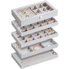 three white jewelry boxes stacked on top of each other with different types of rings in them