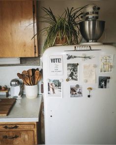 a white refrigerator freezer sitting in a kitchen next to a counter top with pots and pans on it