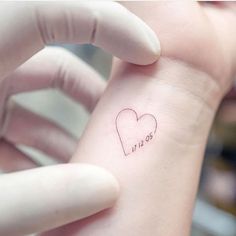 a small heart tattoo on the wrist that says i love you in cursive writing