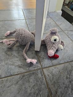 a stuffed animal laying on the ground next to a door