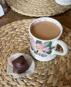 there is a cup of coffee and some chocolates on the table