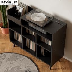 a record player is sitting on top of a shelf with records and cds in it