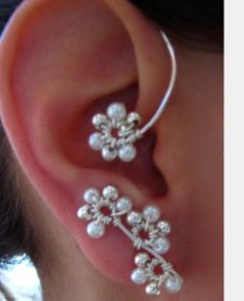 a close up of a person's ear with pearled flowers on the side