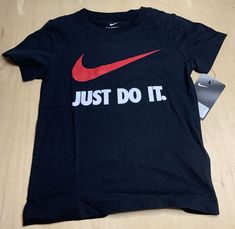 Introducing a stylish and comfortable Nike Just Do It Graphic T-Shirt in striking black, red and white colorway, specially designed for children. This unisex t-shirt with short sleeves is made from 100% cotton material that is soft to the touch and machine washable for easy maintenance. The shirt features the iconic Nike logo as its theme, adding a touch of sporty elegance to any outfit. Perfect for young boys and girls, this Nike t-shirt is available in size 6 and comes with tags attached. With free shipping included, this is a must-have item for any young fashion enthusiast. Fashion Enthusiast, Nike Tshirt, Young Fashion, Nike Just Do It, Must Have Items, Nike Logo, Just Do It, Cotton Material, Black Red