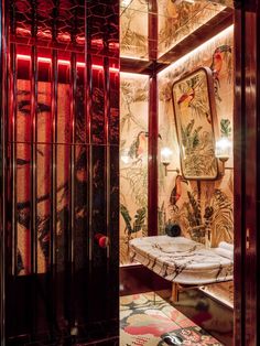 the bathroom is decorated with exotic wallpaper and red lighting, along with a marble countertop