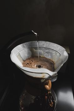 a coffee pot filled with liquid on top of a stove